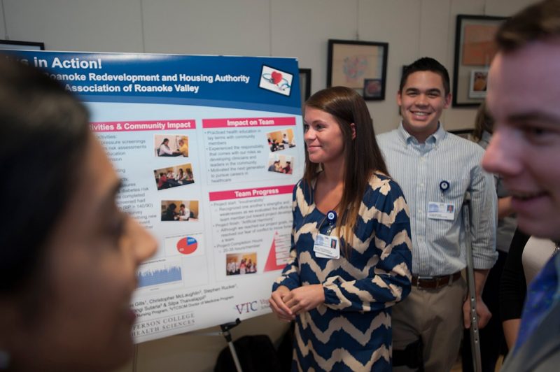 Students discuss their service learning project during the poster presentation day.