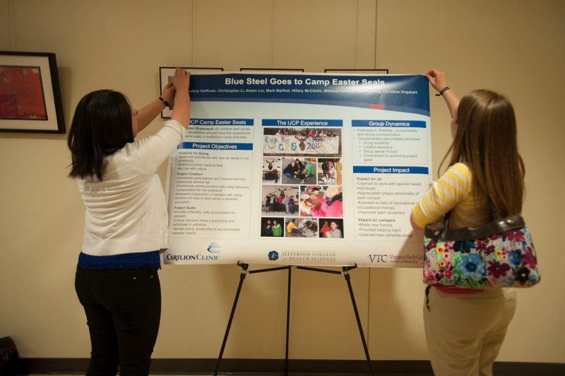 Students setting up their poster for the Service Learning Poster day.