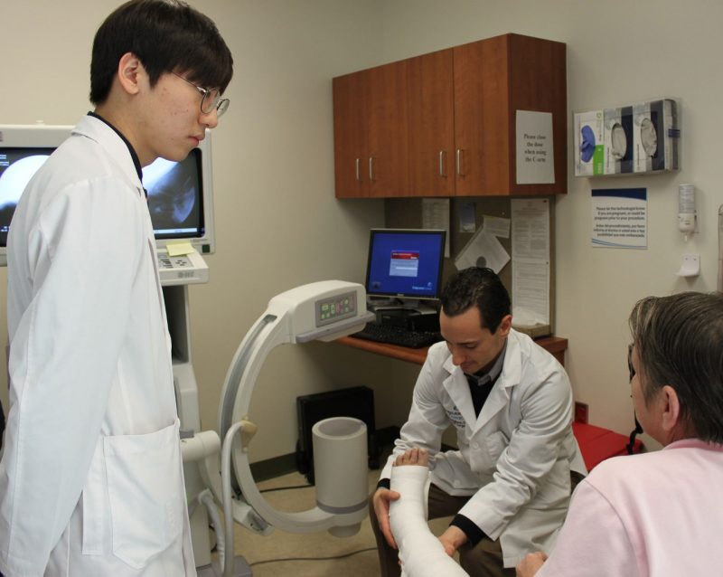 Student JongWook Oh observes as Dr. Franco Coniglione re-casts patient Frances Huffman's ankle.
