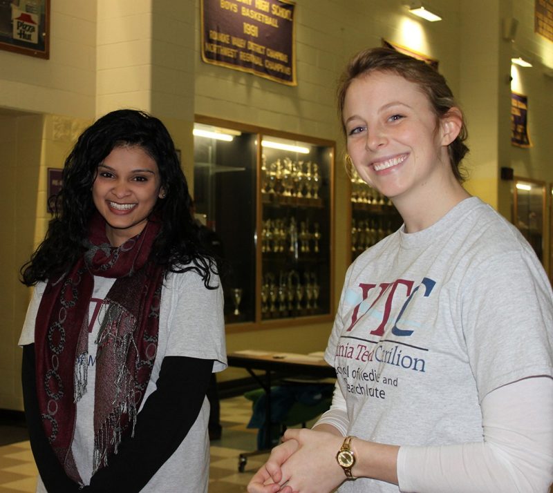 Tarangi Sutaria, '17, and Caroline Reist, '18, greet guests near the donation table.
