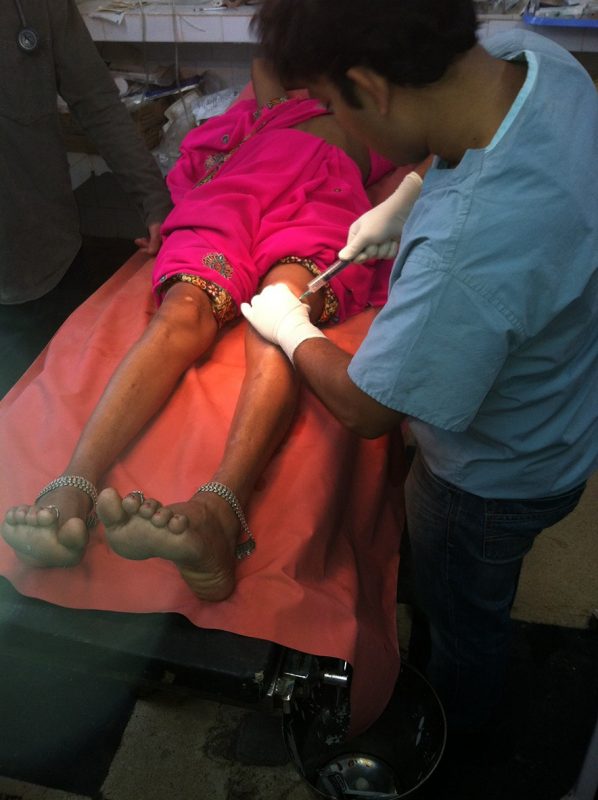 An orthopaedist taps a patient's joint at Christian Hospital Mungeli.