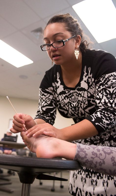 Amber Diaz-Keith of the Virginia Tech Carilion School of Medicine creates a "wound" with makeup (in a process called moulage) during the 2015 mini medical school.