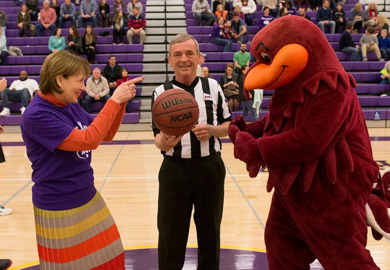 Carilion Clinic CEO Nancy Agee faces off against the Hokie Bird at tip-off.