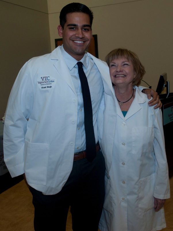 Vivek Singh poses with Dean Cynda Johnson, MD, after receiving his white coat.