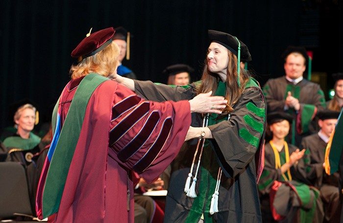 Graduate Lauren Poindexter is overjoyed to receive her diploma from Dean Cynda Johnson. 