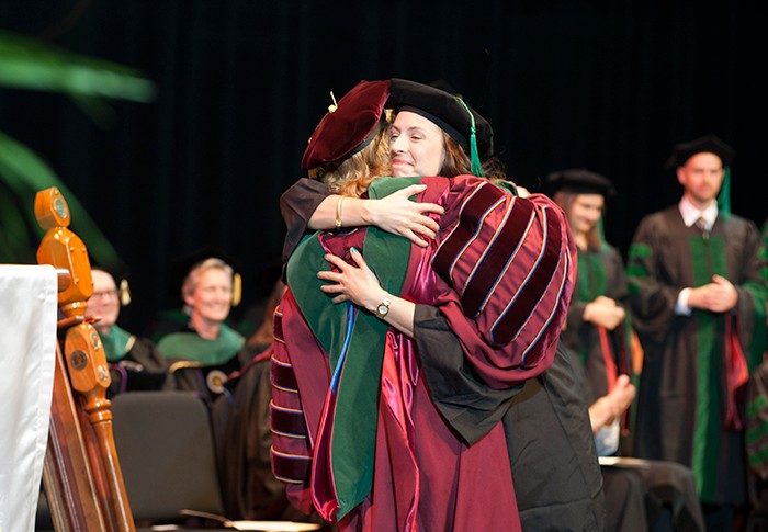 Lauren Poindexter embraces Dean Cynda Johnson as she receives her diploma.