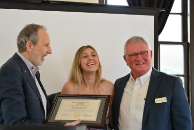 Dean Learman presented the award to graduating resident Dr. Brooke Jensen. They were joined at the podium by Dr. Michael Hart.