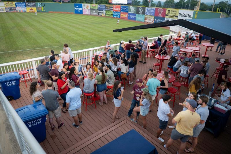 A group of people are gathered on the Carilion deck at the Salem Red Sox game