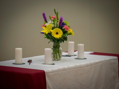 Table with a floral bouquet surrounded by four unlit candles.