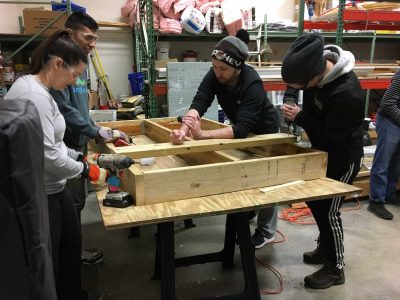 four volunteers constructing a wall frame