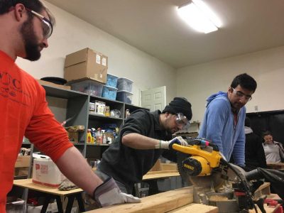 three students working with a table saw