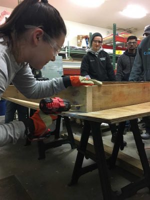 student inserting screws to create a box