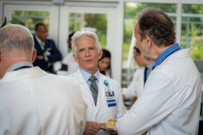 Robert Trestman, chair of the Department of Psychiatry and Behavioral Medicine speaks with Dean Lee Learman at a reception.