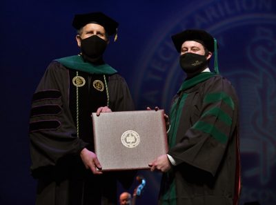 Dean Learman giving a student their diploma