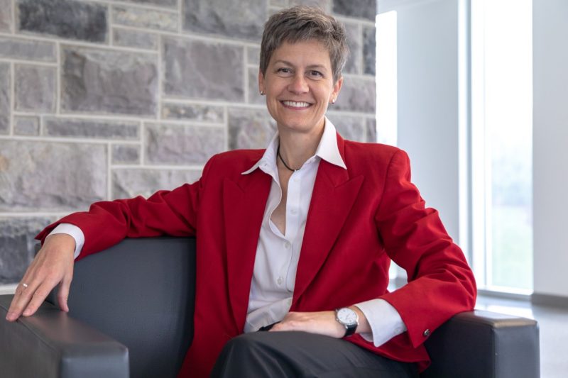 Woman wearing red blazer with white shirt underneath.