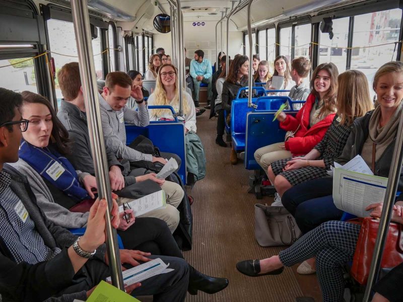 A bus full of applicants engaging with each other during a tour.