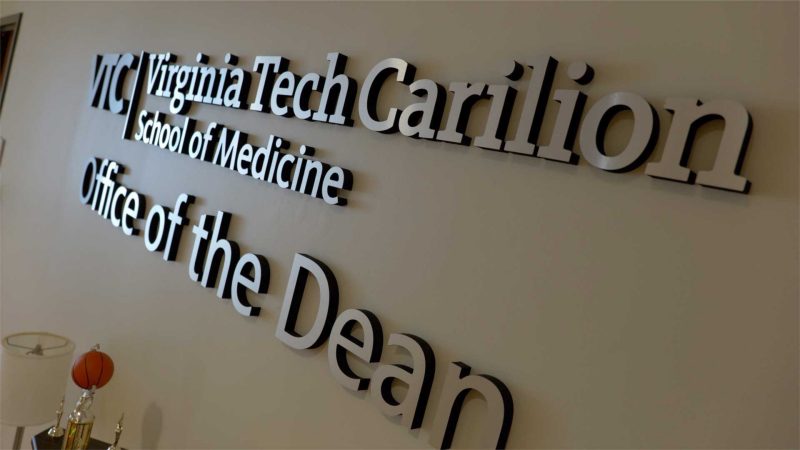 Signage on the wall saying Virginia Tech Carilion School of Medicine Office of the Dean