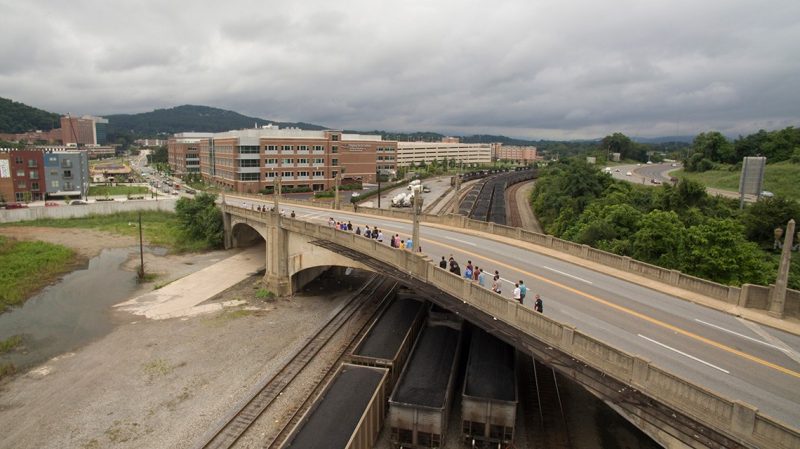 Public Health walk participants walking over the Jefferson Street bridge with the school in the background.