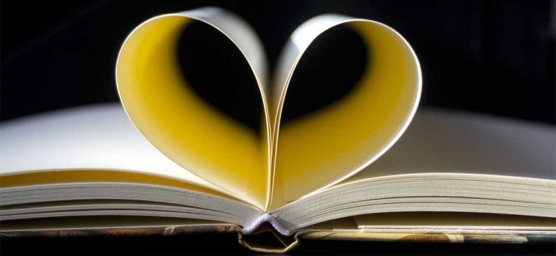 open-faced books with center pages curled in to form a heart