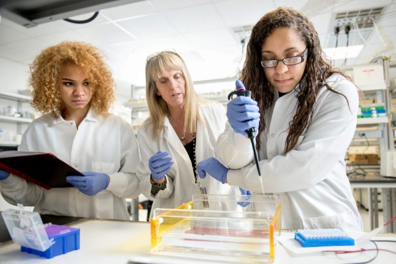 Three women conducting a lab experiment