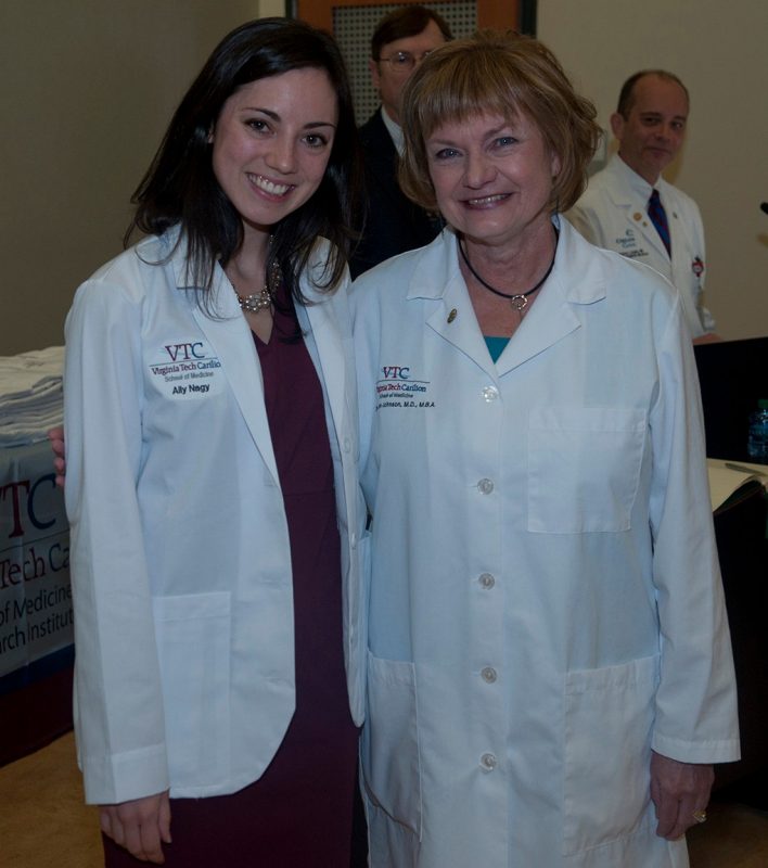Ally Nagy poses with Dean Johnson after receiving her white coat.