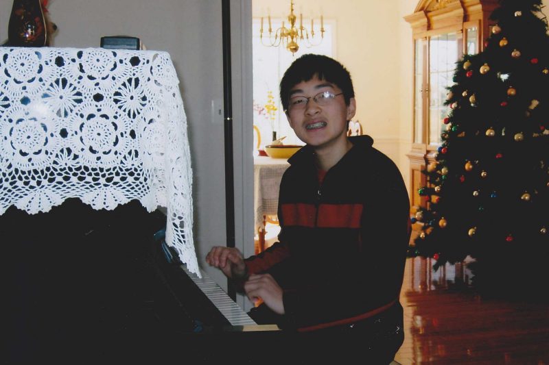 Steve Qian playing the piano as a teenager