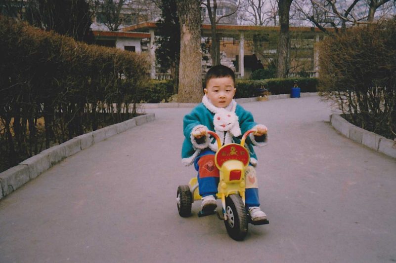 Steve Qian on a tricycle as a child